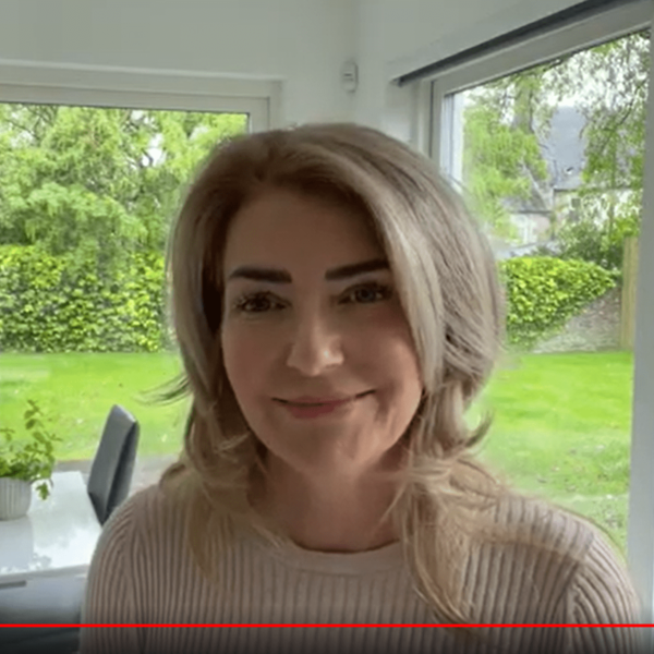 Woman smiling in bright room with garden.