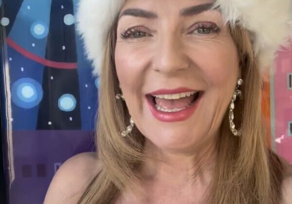 Woman smiling in festive winter hat.