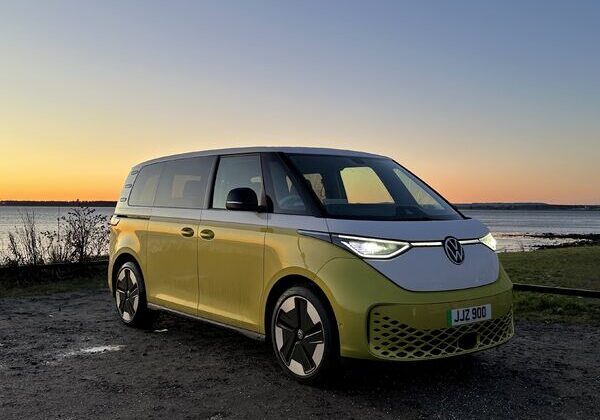 Yellow van parked by a lakeside sunset.