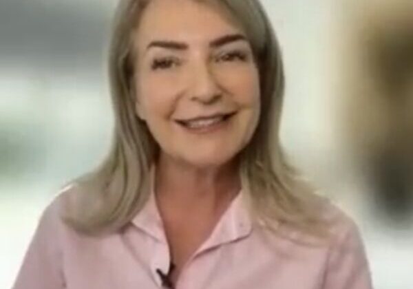 Smiling woman in a pink shirt.