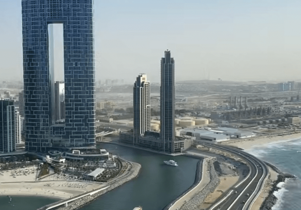 Modern skyscrapers along a coastal highway.