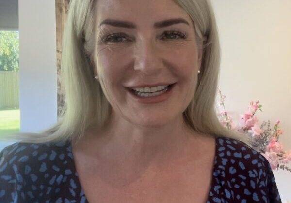 Smiling woman in floral dress indoors.